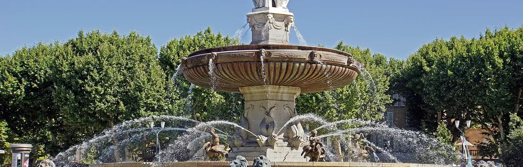La fontaine de la Rotonde et les platanes du Cours Mirabeau à Aix-en-Provence, sous la lumière dorée de Provence