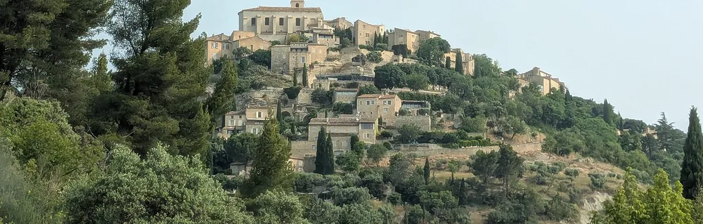 Le village perché de Gordes au coucher du soleil, vu depuis la route, illustrant le budget d'un séjour dans le Luberon en Provence