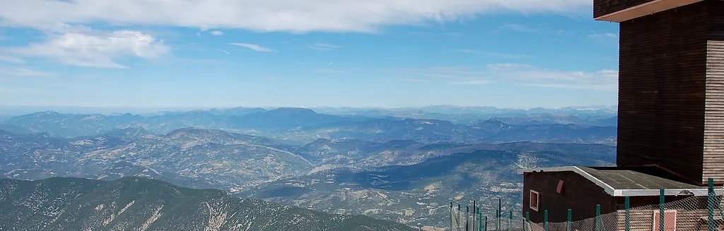 Le sommet calcaire blanc du Mont Ventoux dominant la Provence sous un ciel bleu, route en lacets et désert minéral du géant de Provence