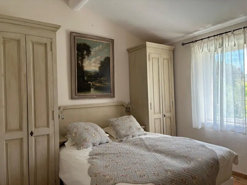 Chambre avec tableau ancien, armoires provençales et vue sur le jardin